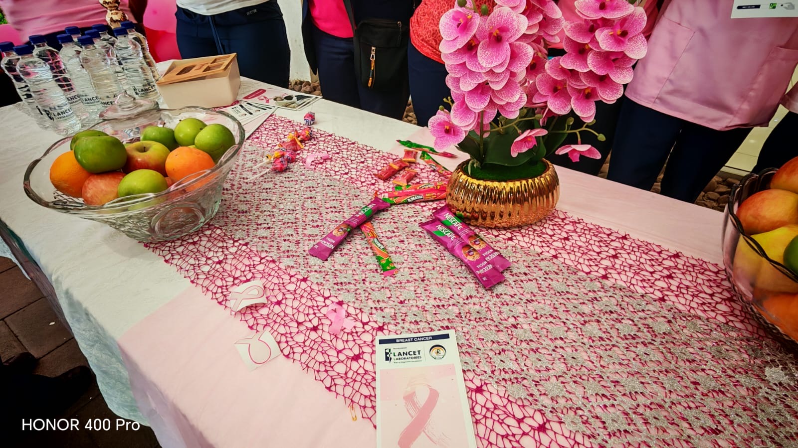 Breast cancer awareness table at Garden City with pink ribbons, information leaflets, fruit and pink flowers
