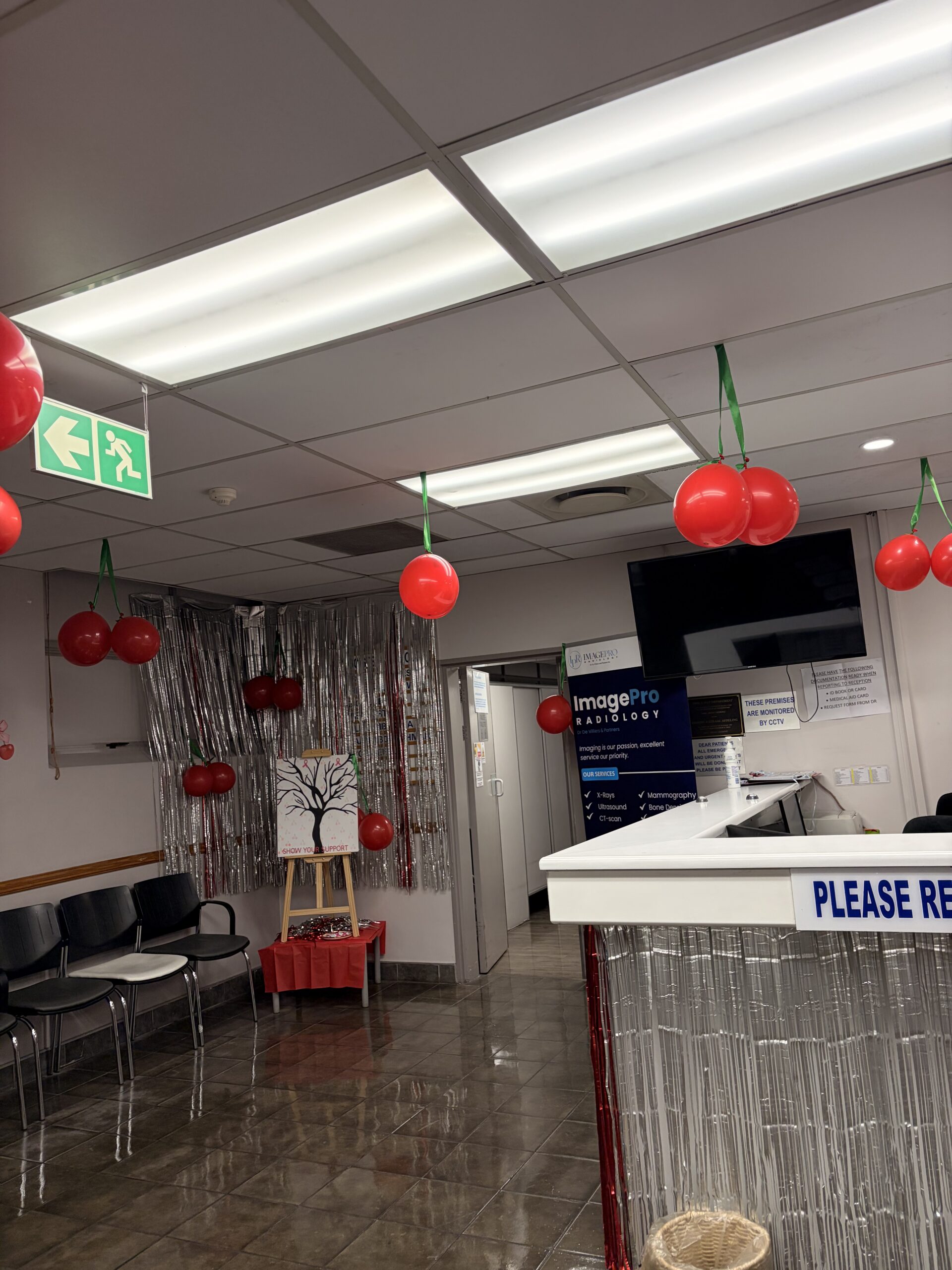 ImagePro Radiology reception with red balloon decorations, silver streamers and the support tree display